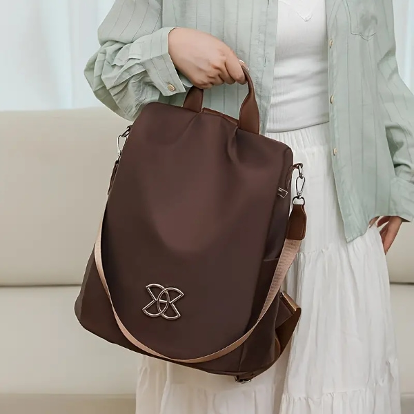 Mulher a segurar a mochila antirroubo castanha