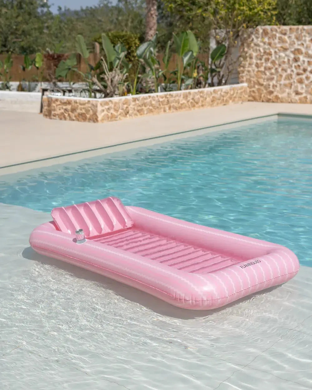 Piscina insuflável individual rosa a flutuar na piscina, com almofada e porta-copos