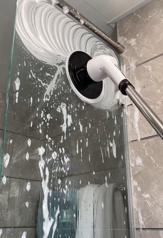 Escova elétrica rotativa a limpar o vidro do chuveiro cheio de espuma, sem esforço