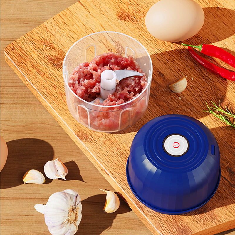 Mini picadora a picar carne fresca na tábua, com alho ao lado